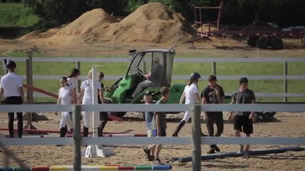 Minsk, Bielorrússia - 19 de julho de 2019: as pessoas limpam a arena após competições equestres no rancho equestre. Plano global — Vídeo de Stock
