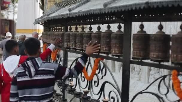 Kathmandu, Nepál - 2019. november 14.: Szoros rálátás a forgó buddhista imakerekekre egy sor kerékben Nepál Katmanduban. Templom. — Stock videók