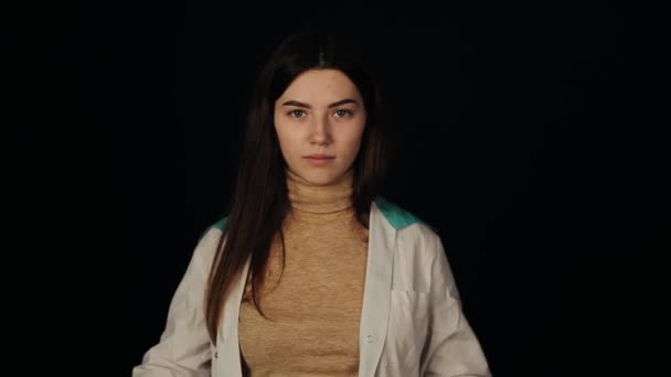 Ragazza in un cappotto medico indossa una maschera protettiva e ride — Video Stock