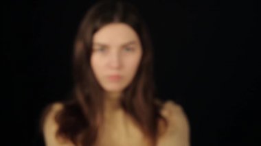 Kafkas bir kadın doktor kameraya bakıyor ve iki Coronavirus COVID-19 modelini işaret ediyor. Karanlık arka plan. İzole edilmiş. Eller yukarı. Bulanık görüntü