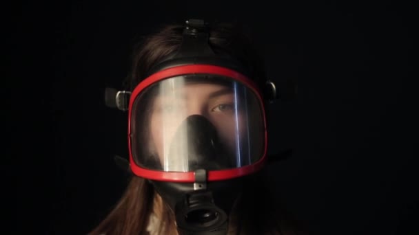 Dívka v červené plné tváři maska respirátor se rozhlíží kolem — Stock video