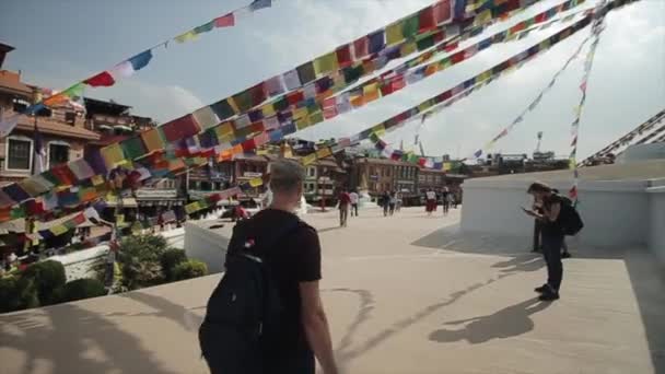 Kathmandu, Nepal - 14 de novembro de 2019: Um templo nepalês branco, stupa. Pessoas a subir as escadas até ao templo. Céu brilhante. Dia ensolarado. Nepal Kathmandu . — Vídeo de Stock