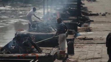 Katmandu, Nepal - 14 Kasım 2019: Pashupatinath tapınağı yakınlarında yakma töreni düzenleyen bir adam. Yanan cesetler..