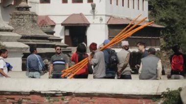 Katmandu, Nepal - 14 Kasım 2019: Katmandu, Nepal 'de turuncu tahta çubuklar taşıyan Nepal' li bir adam.