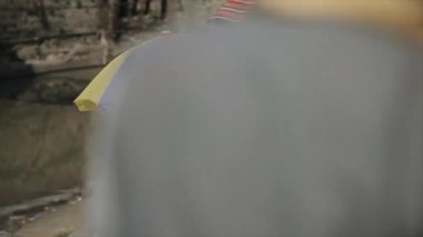 Katmandu, Nepal - 14 Kasım 2019: Beyaz tişört giyen yaşlı bir Nepal 'li. Nepal sokaklarındaki insanlar. Katmandu, Nepal. Şehirdeki bir nehir kıyısında dinleniyor..