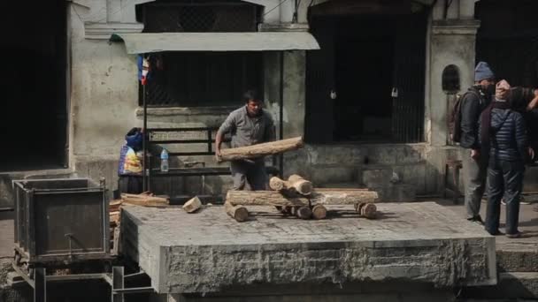 Kathmandu, Nepál - 2019. november 14.: Egy férfi tűzifát készít, hamvasztási ceremóniára készül a nepáli Kathmanduban. — Stock videók