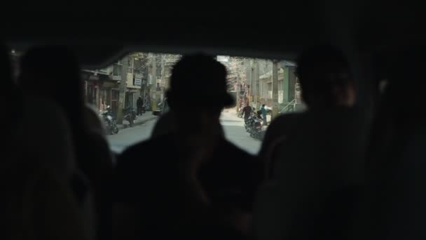 Kathmandu, Nepál - 2019. november 19.: Kilátás egy autóból a nepalesei forgalmi dugóra Kathmanduban. Forgalmas utak, városközpont. Három férfi ül a hátsó ülésen. — Stock videók