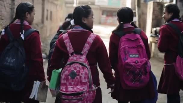 Katmandú, Nepal - 14 de noviembre de 2019: Un grupo de niñas nepalesas en uniforme escolar caminando por la calle. Nepal Katmandú. En cámara lenta. Vista trasera trasera . — Vídeos de Stock