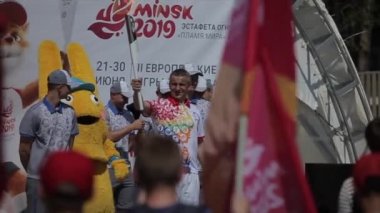 Minsk, Belarus - 19 Temmuz 2019: Olimpiyat meşalesi tutan bir atlet, 2 Avrupa Oyunları 'nda diğer sporcularla birlikte koşuyor