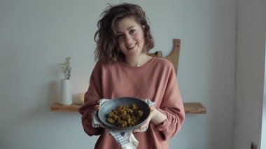 Güzel, genç, mutlu bir kız brokoli ile pişirilmiş bir yemek gösteriyor.