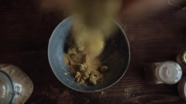한 소녀는 브로콜리에 향신료를 섞어 높은 곳에서 그릇에 던진다. 위에서 바라본 경관 — 비디오