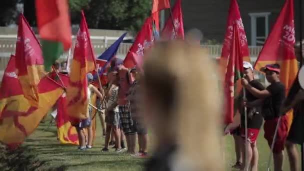 Минск, Беларусь - 19 июля 2019 года: Группа подростков, стоящих на газоне и размахивающих флагами — стоковое видео
