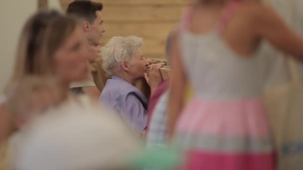 Minsk, Biélorussie - 19 juillet 2019 : Un groupe de spectateurs de différents âges et une femme âgée se sont penchés sur la clôture. Plan flou — Video