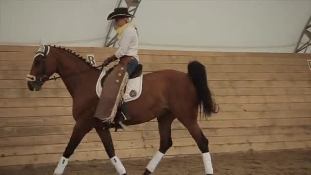 Minsk, Belarus - 19 juli 2019: Mooie jonge amazone in cowboykostuum op een paardenranch dressuurconcours. Langzame beweging. Close-up — Stockvideo