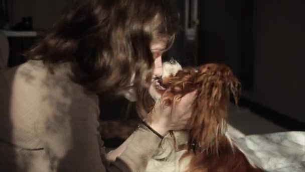 Красивая европейская девушка целует свою собаку через медицинский mask.Coronavirus.COVID-19 — стоковое видео