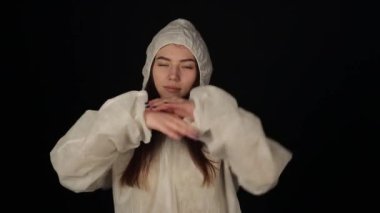 Koruyucu takım elbiseli neşeli kız el yıkama dansı yapıyor. Çılgın dans. Kadın ellerini nasıl yıkayacağını gösterir.