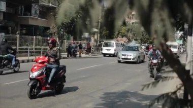 Katmandu, Nepal - 23 Kasım 2019: işlek Nepal yolunun kapatılması. Bisiklet, araba, motosiklet kullanan insanlar. Palmiye ağaçları.