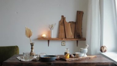 Güzel gülümseyen genç bir kız mutfağındaki masaya gelir ve ev yapımı humus pişirir.