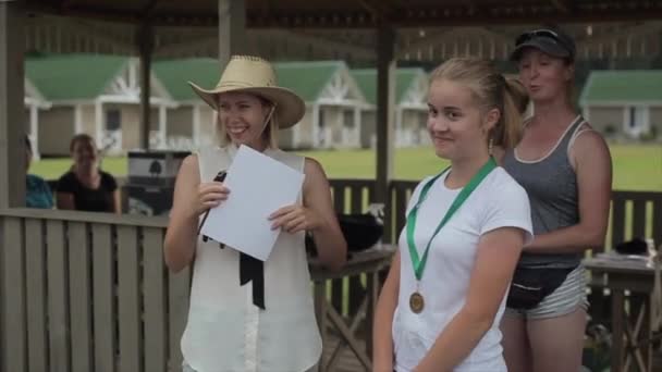 Minsk, Vitryssland - 19 juli 2019: En ung söt flicka tilldelas medalj och diplom nära lusthuset på gatan. Närbild — Stockvideo