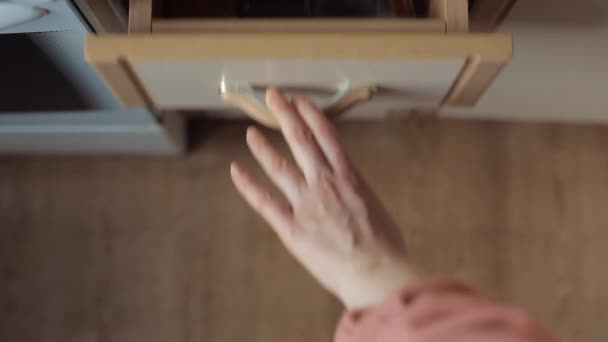 Fille montre comment stocker des épices dans des bocaux en verre dans un tiroir de la table de cuisine. Gros plan 