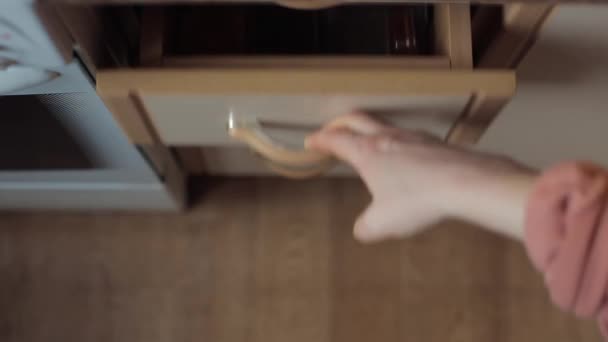 Fille montre comment stocker des épices dans des bocaux en verre dans un tiroir de la table de cuisine. Gros plan 