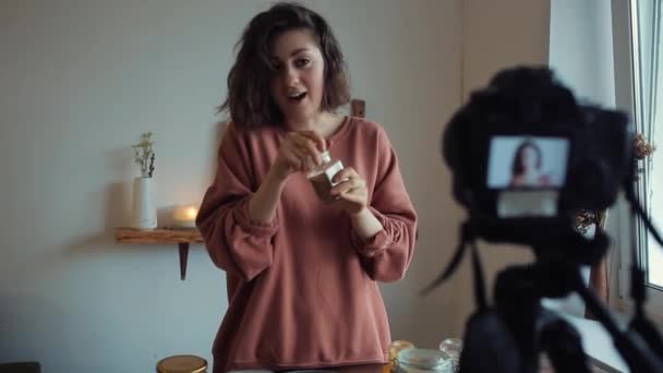 Размытый снимок девушки-блогера на кухне, которая говорит о еде для своего блога — стоковое видео