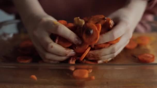Mâinile fetei amestecă morcovi feliați cu condimente și sos pentru a pregăti un fel de mâncare sănătos. Close-up — Videoclip de stoc