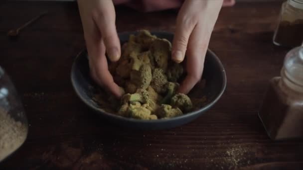 In Zeitlupe mischt eine Mädchenhand Brokkoli mit Gewürzen in einer Schüssel, um gesundes Essen zu kochen. Nahaufnahme — Stockvideo