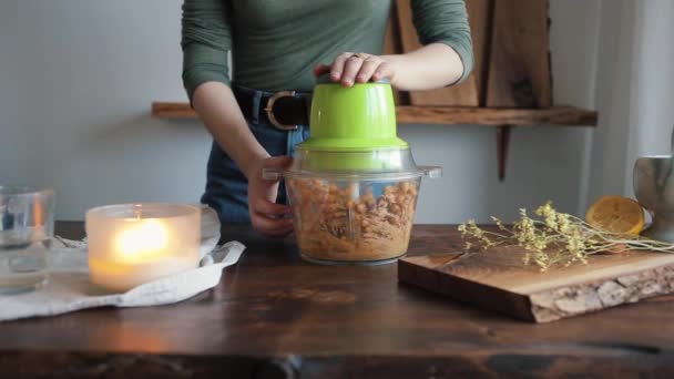 A young girl added water to a blender and mixes all the ingredients in it to get homemade hummus. Close-up — Stock Video