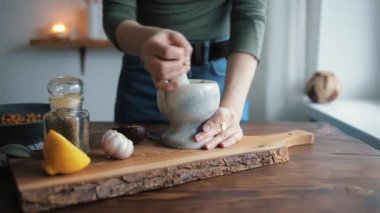 Mutfaktaki genç bir kızın eli, el yapımı humusa eklemek için havana baharat koyar.