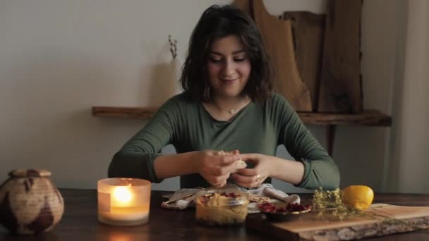한 아름다운 소녀가 그녀가 요리 한 부엽토를 먹고 그녀의 개는 식탁에 앉아 그녀를 지켜 봅니다. 클로즈업 — 비디오