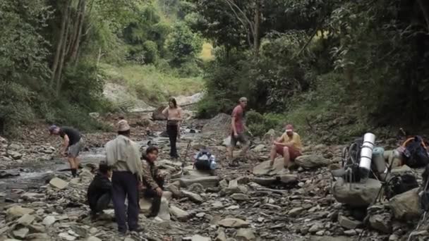 Pokhara, Nepal - 18. November 2019: Kaukasische Wanderer machen an einem Bach Rast. Wald — Stockvideo