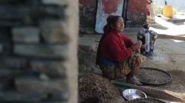 Pokhara, Nepal - 18 Kasım 2019: Nepal 'li bir kadın sokakta pirinç tanelerini ayırıyor,.