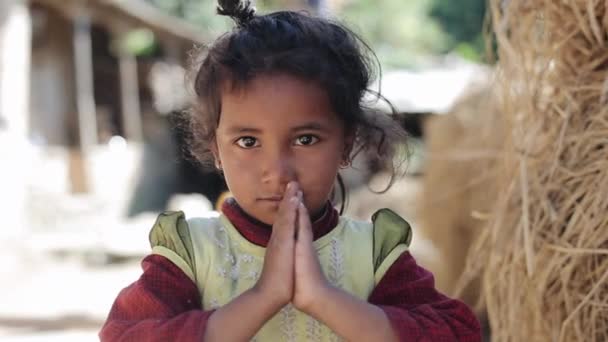 Pokhara, Nepal - 18 November 2019: A closeup of a beautiful cute nepalese girl. Looking into the camera. Praying hands. She says namaste. — Stock Video