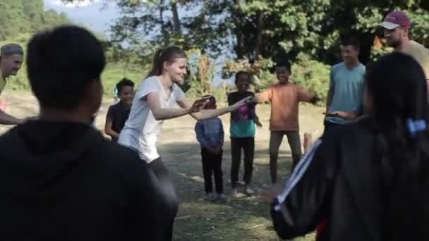 Pokhara, Nepal - 18 november 2019: Een Kaukasische jonge vrouw die buiten danst met nepalese kinderen. Vrijwilliger. — Stockvideo