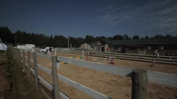 Mińsk, Białoruś - 19 lipca 2019: Dżokej jeździ konno skacząc przez przeszkody w zawodach jeździeckich. Zwolniony ruch — Wideo stockowe