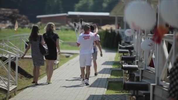 Minsk, Weißrussland - 19. Juli 2019: 2 Männer asiatischen Aussehens in Sportuniformen und mit Fackeln für das Feuer 2 Europaspiele — Stockvideo