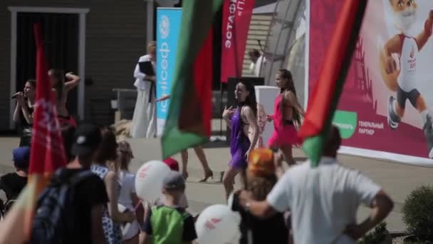 Minsk, Biélorussie - 19 juillet 2019 : Le drapeau biélorusse se développe entre autres au-dessus des têtes du public. Gros plan — Video