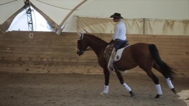 Minsk, Weißrussland - 19. Juli 2019: Schöne junge Reiterin im Cowboykostüm bei einem Dressurwettbewerb auf einer Pferderanch. Zeitlupe. Nahaufnahme — Stockvideo