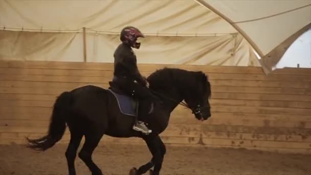 Minsk, Weißrussland - 19. Juli 2019: Ein junger Mann in Uniform und Motorradhelm reitet auf einem Pferd bei einem Dressurturnier auf der Reitanlage — Stockvideo