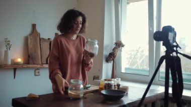 Genç bir kız sebze keser ve yemek hakkında bir blog için kameraya baharatlardan bahseder.