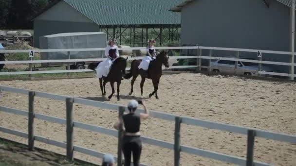 Minsk, Bielorrusia - 19 de julio de 2019: mujeres encantadoras en vestido vintage medieval blanco con un corsé montado a caballo — Vídeos de Stock