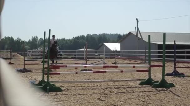 Minsk, Weißrussland - 19. Juli 2019: Zeitlupe von Pferden, die bei Reitturnieren über die Barriere springen — Stockvideo