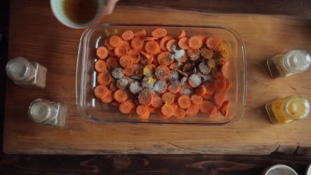 Trancher les carottes dans un bol en verre et les parsemer d'épices et de sel. Gros plan — Video