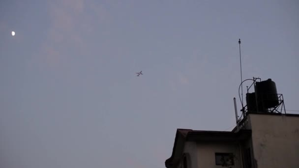 Un aereo in cielo la sera. Vista da una città, angolo basso . — Video Stock