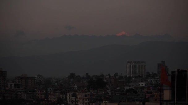 Paisaje urbano de un pueblo indio temprano en la mañana, por la noche. himalayas y everest en el fondo — Vídeo de stock