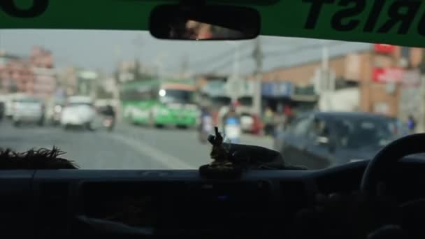 Katmandú, Nepal - 19 de noviembre de 2019: Un pequeño estatuto de Buda en un panel de automóviles. Adorno del coche, salpicadero. Nepal Katmandú. Un coche de conducción . — Vídeo de stock