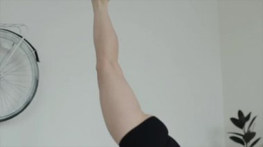 Güzel genç kız evde yoga yapıyor. Yakın plan. Kamera kızların hareketlerini takip ediyor.