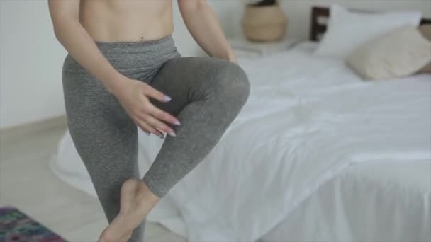 Vacker ung flicka tränar yoga när hon gör övningar hemma. Närbild. Kameran rör sig från botten till toppen — Stockvideo