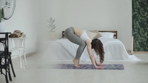 Genç ve çekici kız yoga yapıyor. Güzel odasında paspasın üzerinde dururken farklı pozlar alıyor. — Stok video
